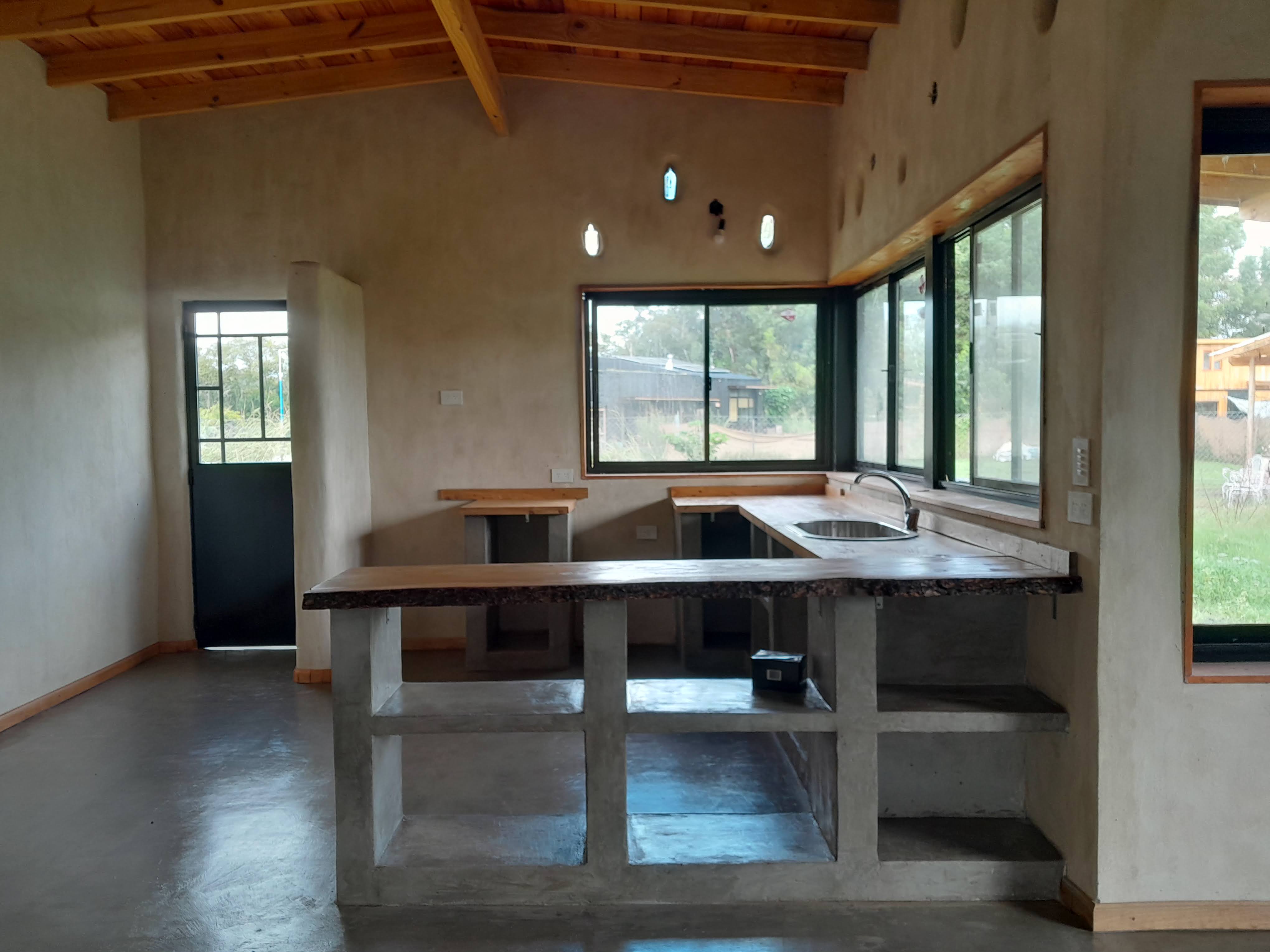 La imagen es la interior de una cocina con mostradores de mármol.