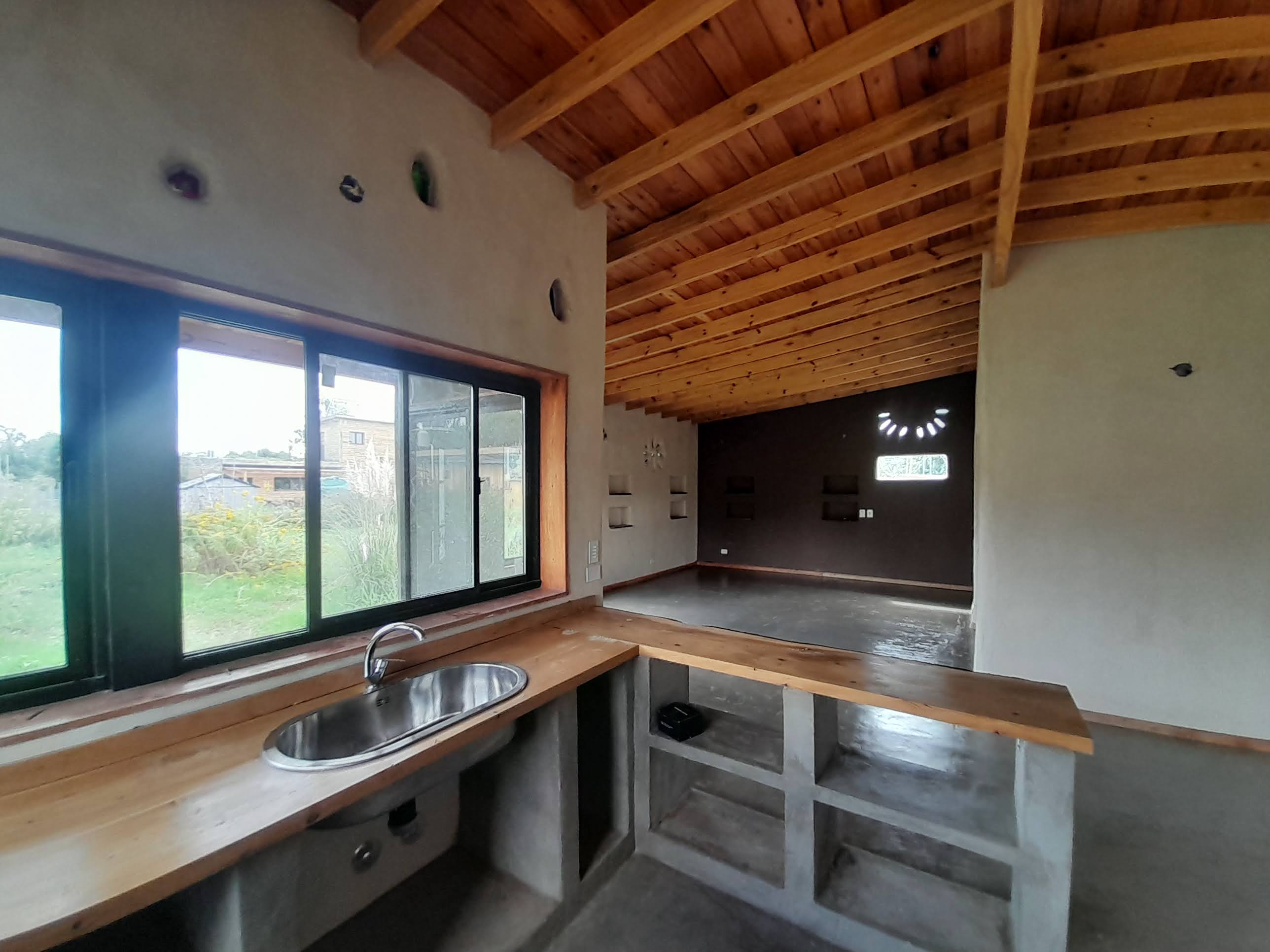 A kitchen with a modern interior and bar sink, showcasing a spacious interior and dotted backup surveillance cameras, set ...
