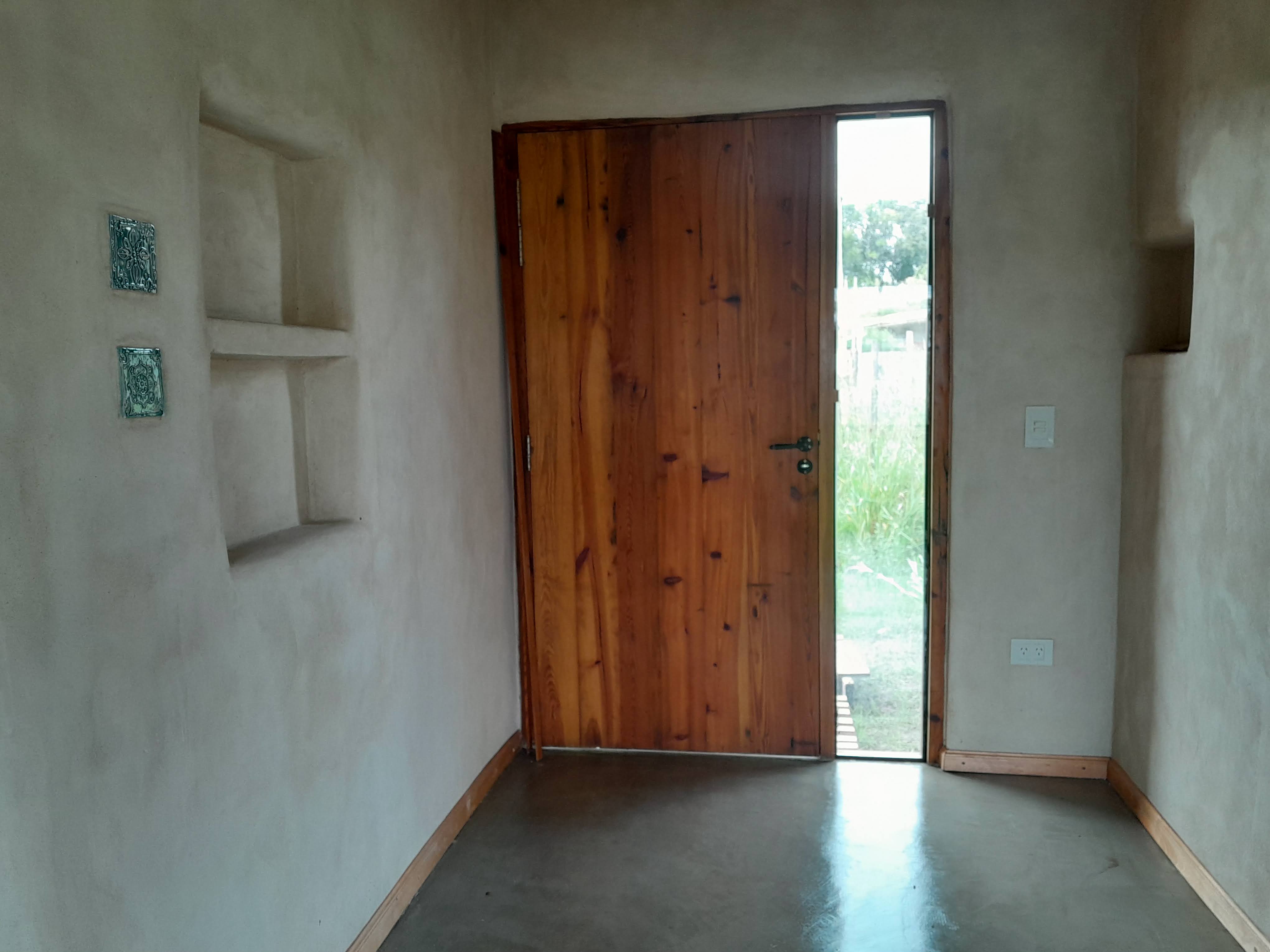 A minimalistic room features an open door and two shelves, creating a simple yet inviting atmosphere. Image Description: T...