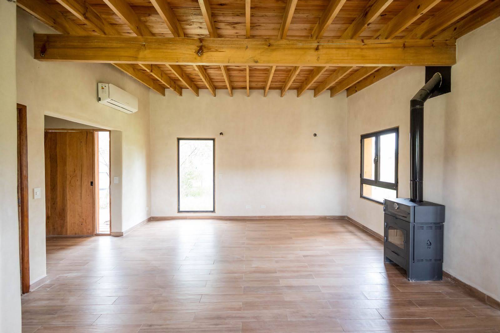 Una habitación grande abierta, con un techo de madera —Mención al objeto: Una especie de estufa.